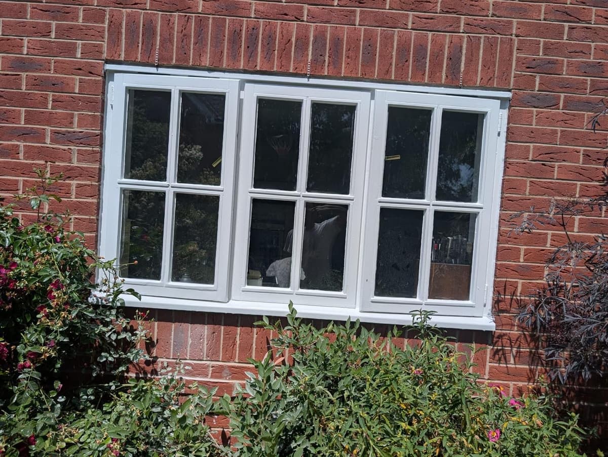 Freshly painted white exterior windows on brick house