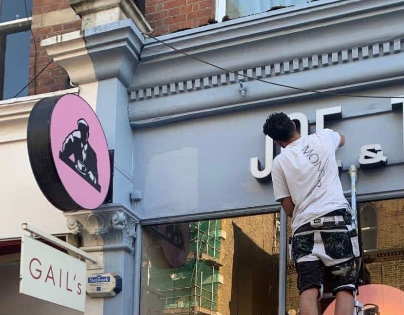 Painter painting commercial shopfront exterior