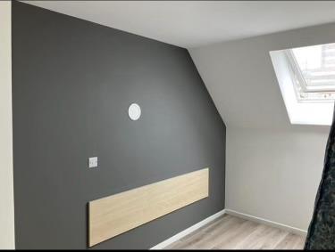 Loft bedroom with dark grey feature wall