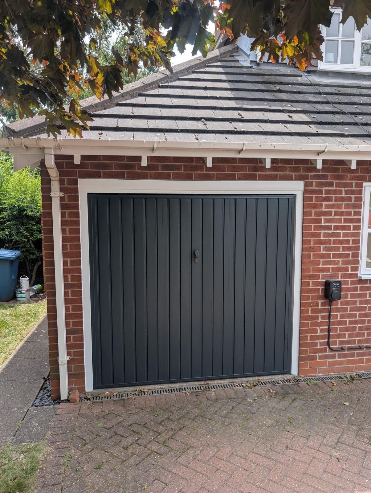 Freshly painted dark grey garage door with white trim