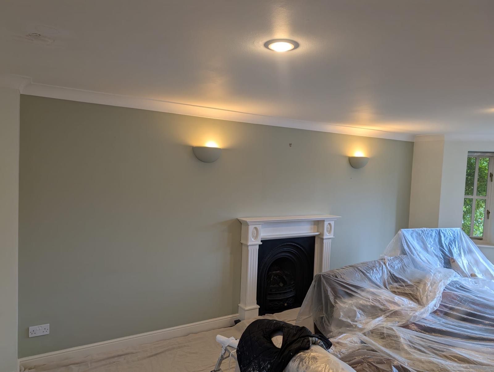 Living room painted sage green with Victorian fireplace