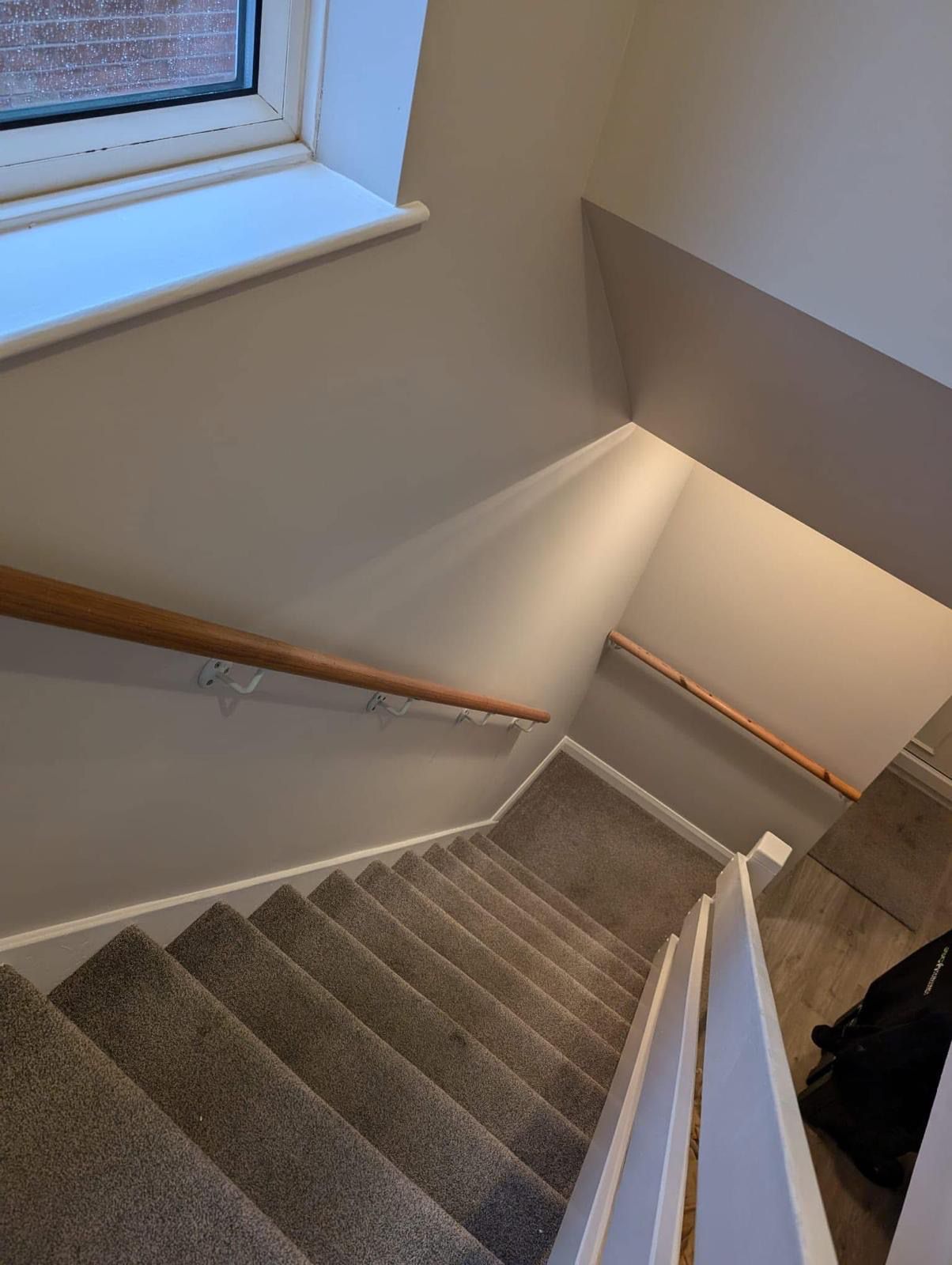 Freshly painted white staircase with oak handrail